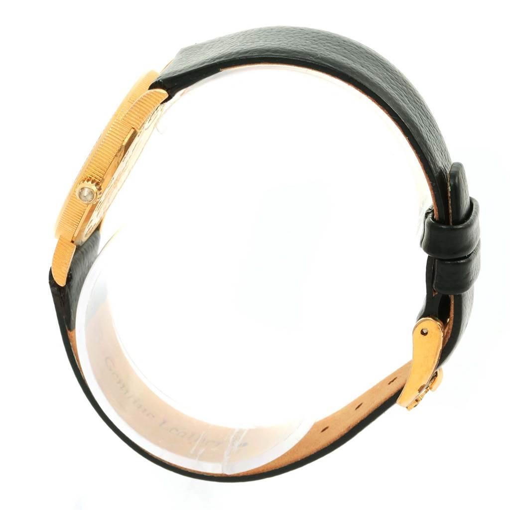 This image shows a side view of the Corum Women's Yellow Gold Black Dial Women's Yellow Gold Black Dial 18K Yellow Gold 10 Dollars Coin Ladies Watch, featuring its gold case and black leather strap.