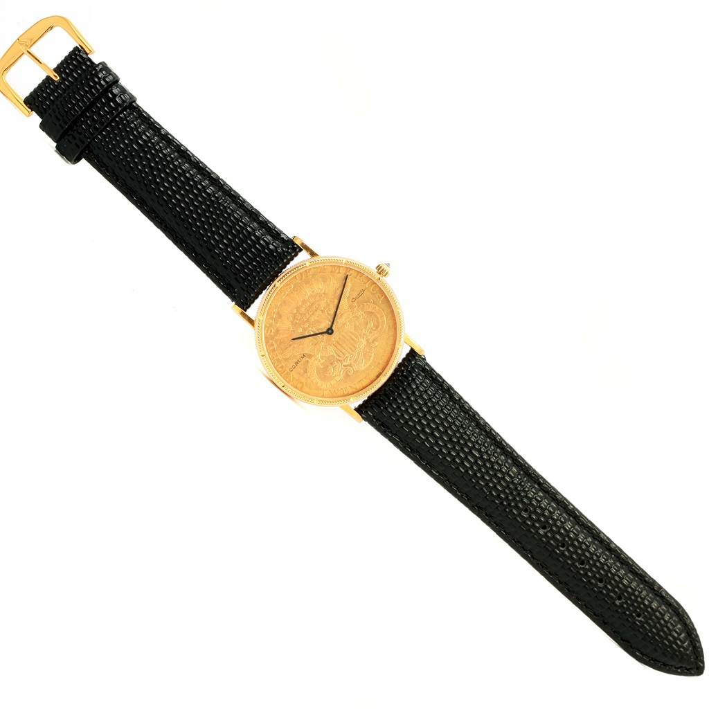 The image shows a Corum Coin Watch Men's Yellow Gold Black Dial Men's Yellow Gold Black Dial model from a top-down angle, displaying the watch face, bezel, crown, and black strap.