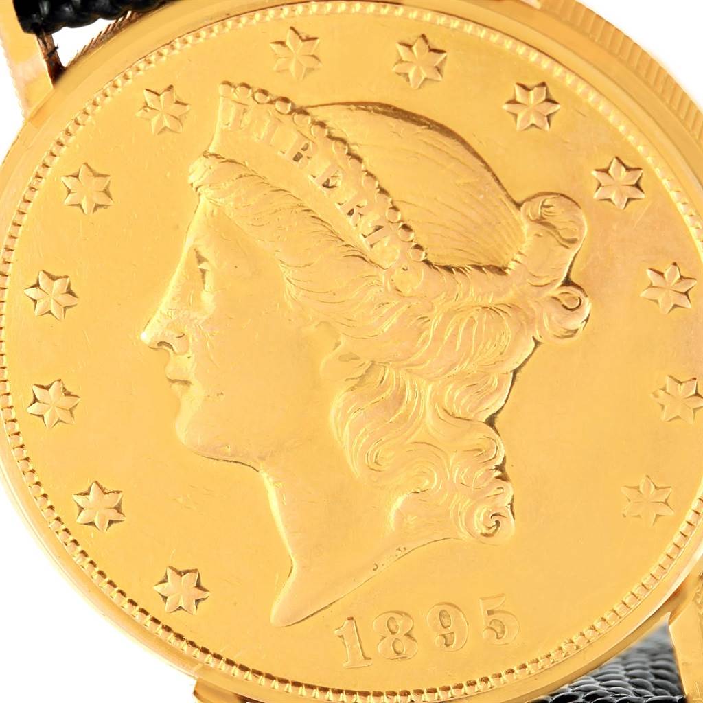 The image shows a close-up of the dial for the Coin Watch model by Corum, featuring a gold coin design and the year 1895.
