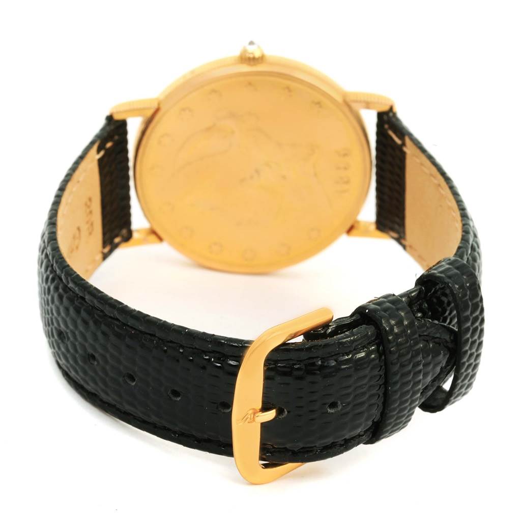 The image shows the back of the Corum Coin Watch Men's Yellow Gold Black Dial Men's Yellow Gold Black Dial model, focusing on the case back, black textured strap, and gold buckle.