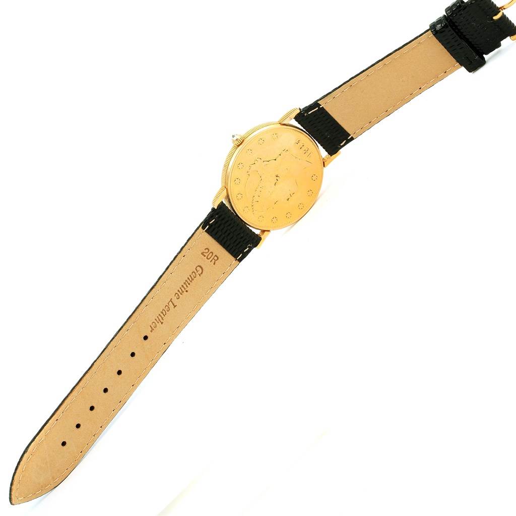 The Coin Watch by Corum is shown from an overhead angle, displaying its gold face and black leather strap.