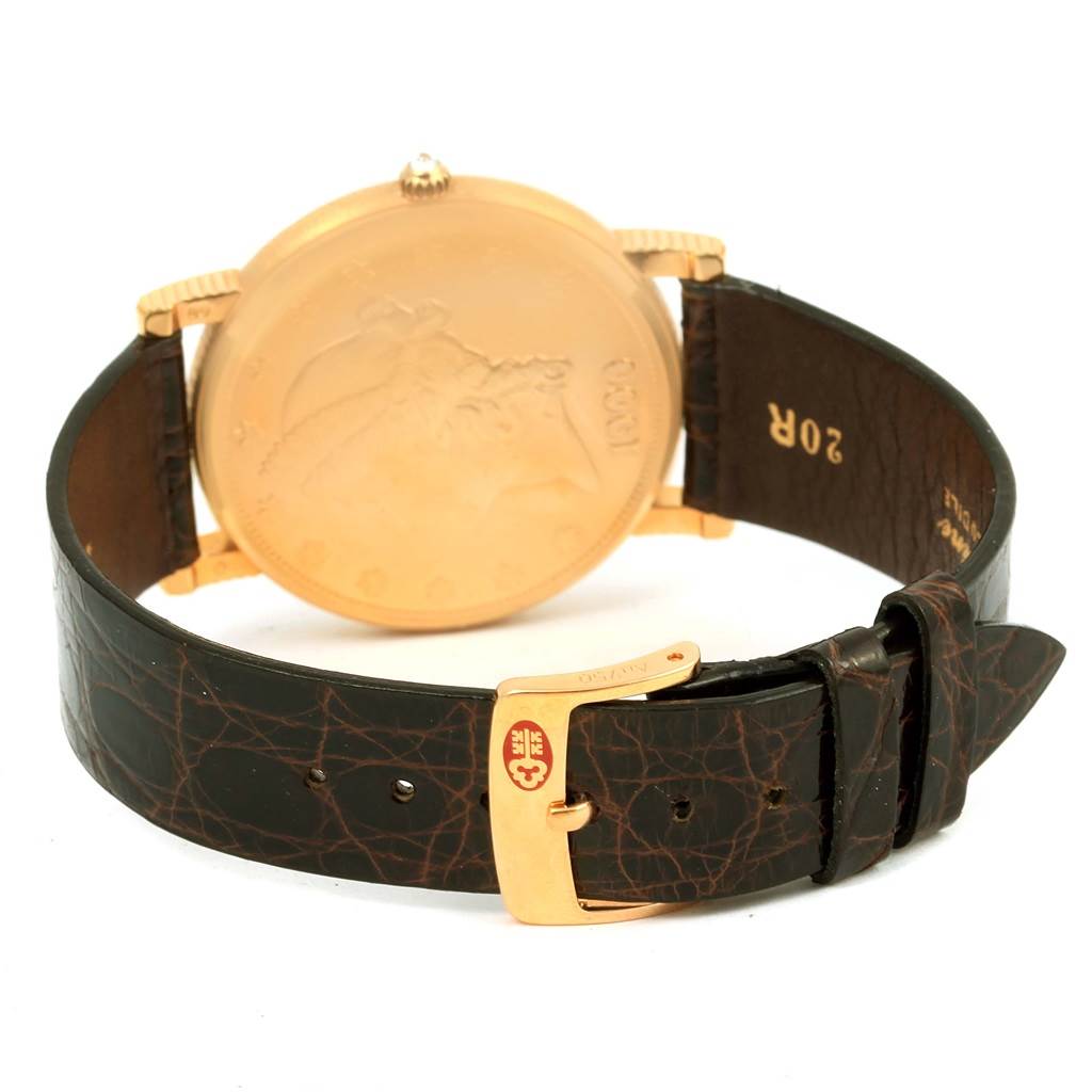 The image shows the back view of a Corum Coin Watch Men's Yellow Gold Black Dial Men's Yellow Gold Black Dial model, including the watch face, case, strap, and buckle.