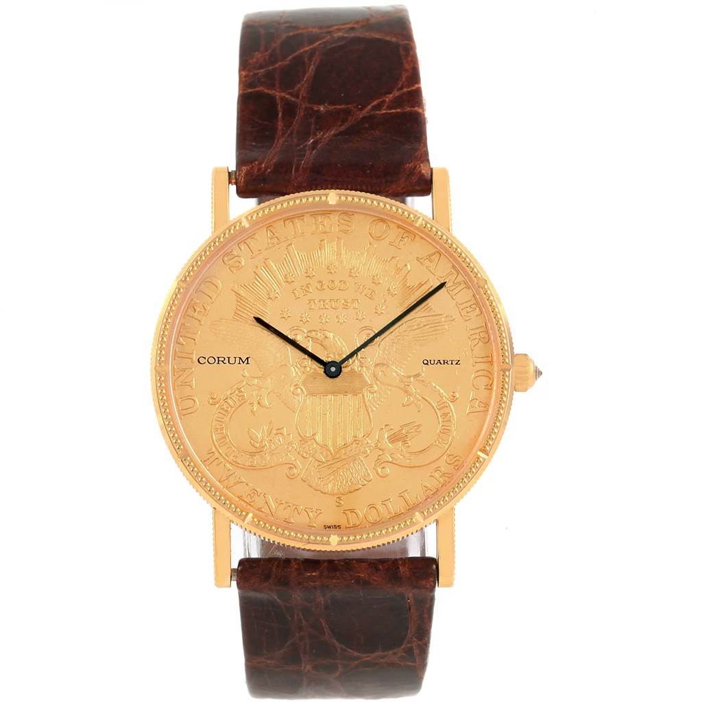 The image shows a frontal view of the Corum Coin Watch Men's Yellow Gold Black Dial Men's Yellow Gold Black Dial, showcasing its gold coin face and brown leather strap.