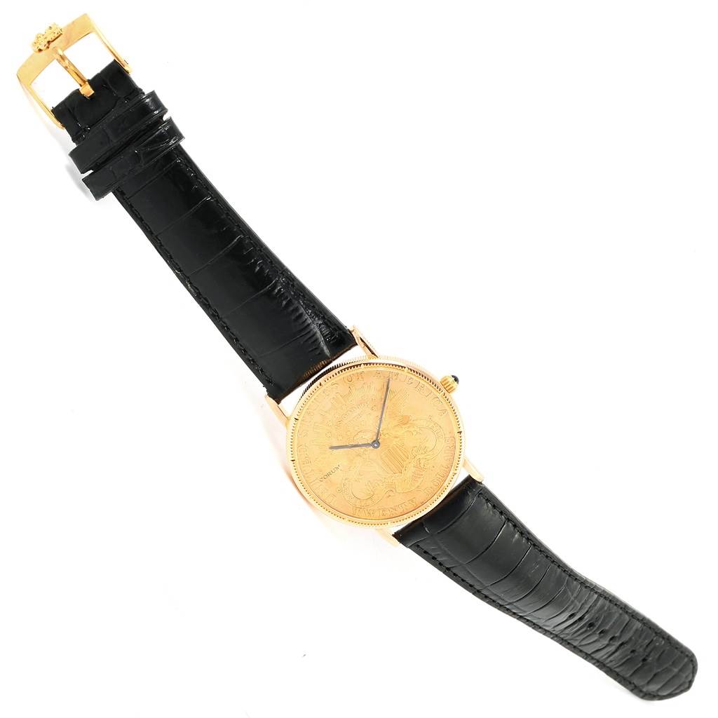 The image shows a Corum Coin Watch  Men's Yellow Gold Black Dial  Men's Yellow Gold Black Dial model from a top-down angle, displaying the watch face and black leather strap.