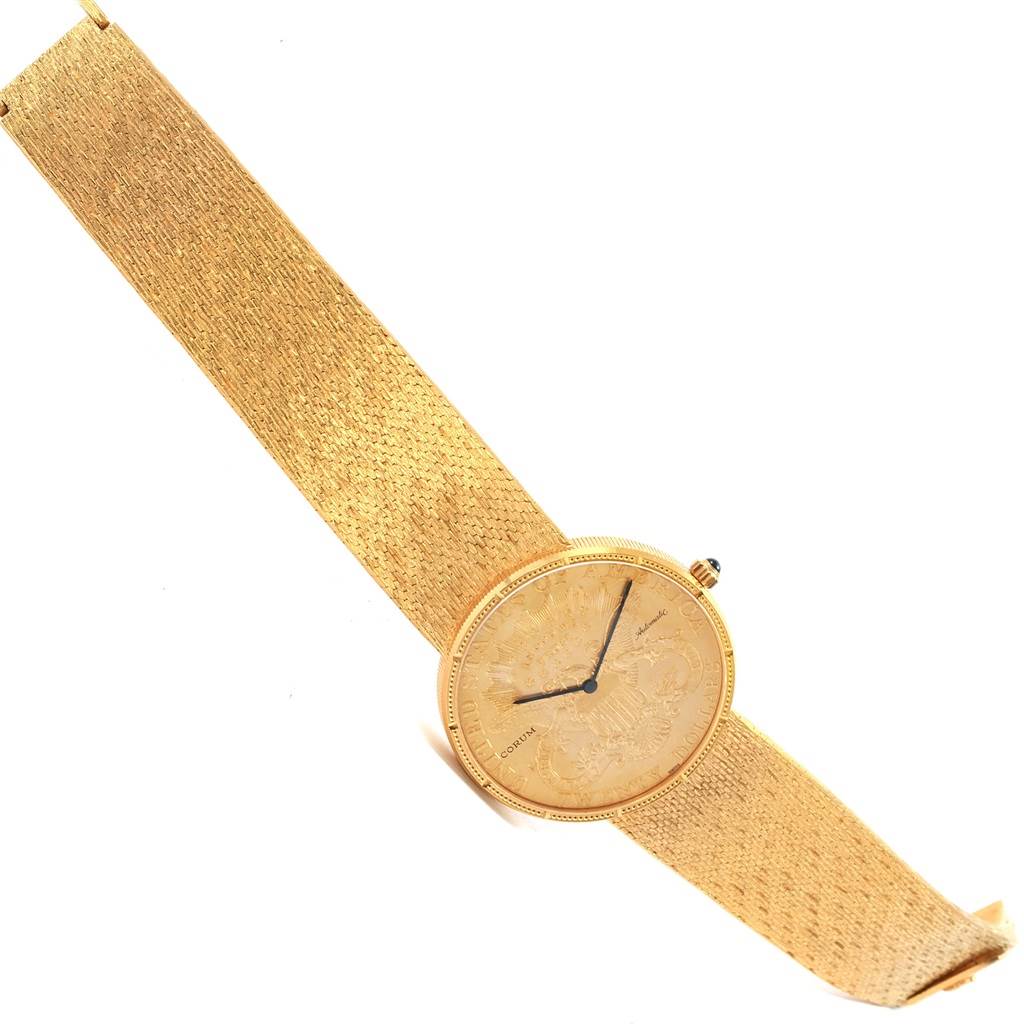 The image shows a Corum Coin Watch Men's Yellow Gold Black Dial Men's Yellow Gold Black Dial model from a top-down angle, highlighting the face and gold-colored strap.