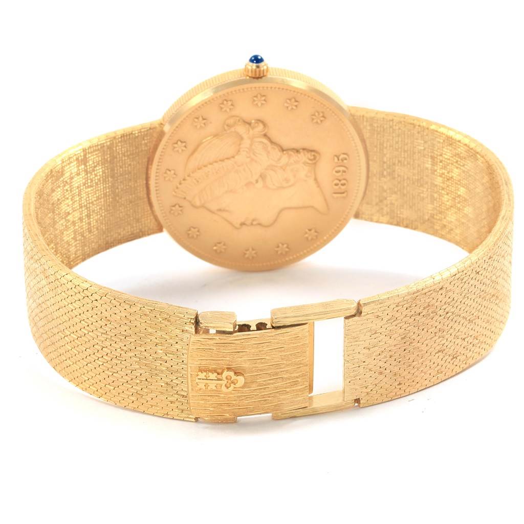 This image shows the back of a Corum Coin Watch Men's Yellow Gold Black Dial Men's Yellow Gold Black Dial model, specifically highlighting its clasp and textured strap.