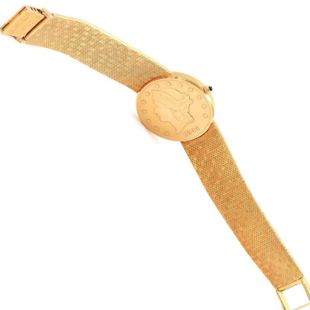 The image shows a top-down view of the Corum Coin Watch Men's Yellow Gold Black Dial Men's Yellow Gold Black Dial model, highlighting the coin design on the watch face and the gold strap.