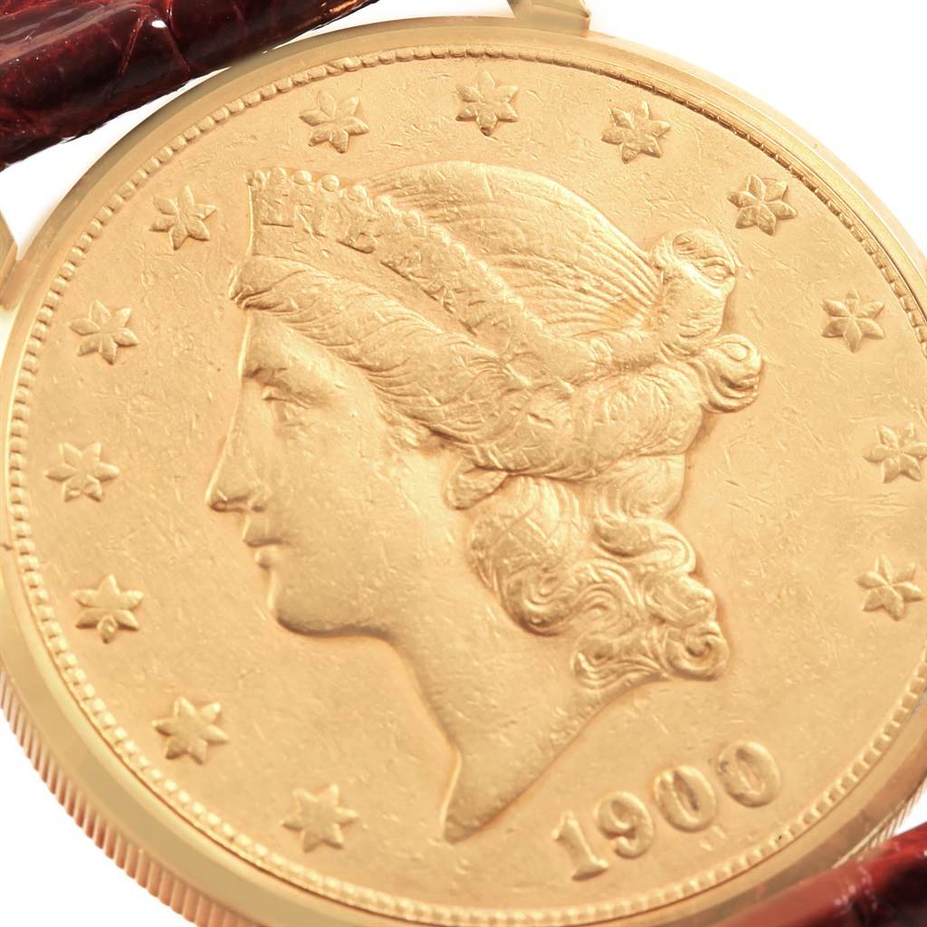 The image shows a close-up of the face of a Coin Watch model by Corum, featuring a gold coin design.