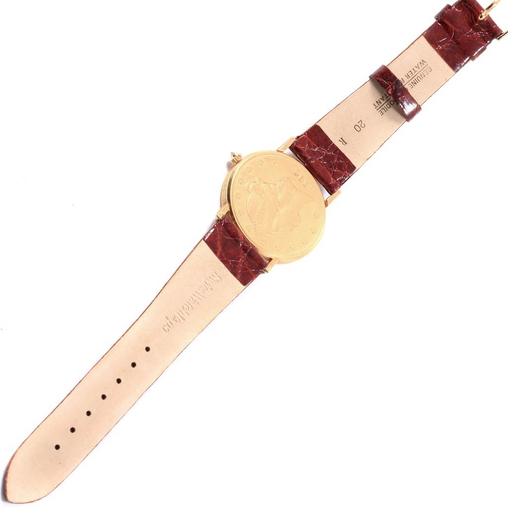 The image shows the back and strap of a Corum Coin Watch Men's Yellow Gold Black Dial Men's Yellow Gold Black Dial model at a top-down angle.