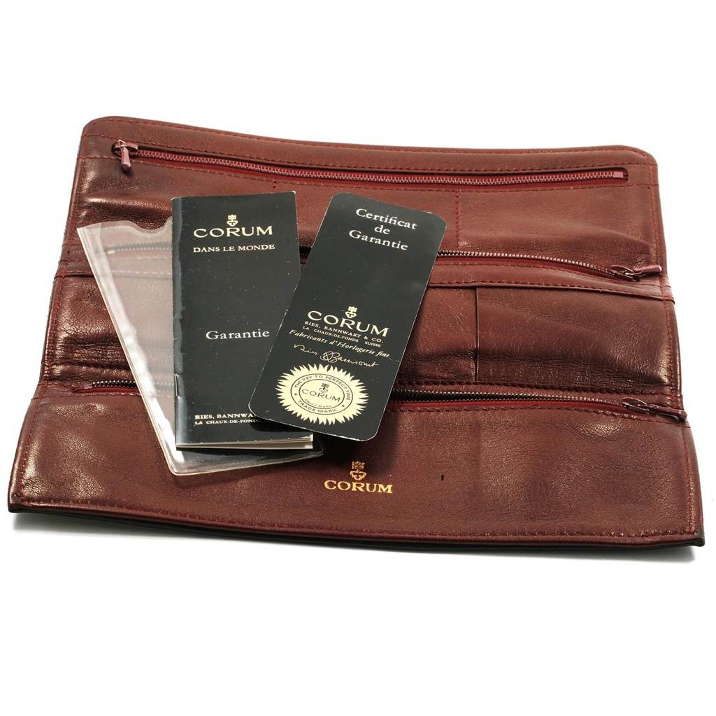 This image shows the accessories for the Corum Coin Watch Men's Yellow Gold Black Dial Men's Yellow Gold Black Dial model, including warranty cards and a brown leather pouch.