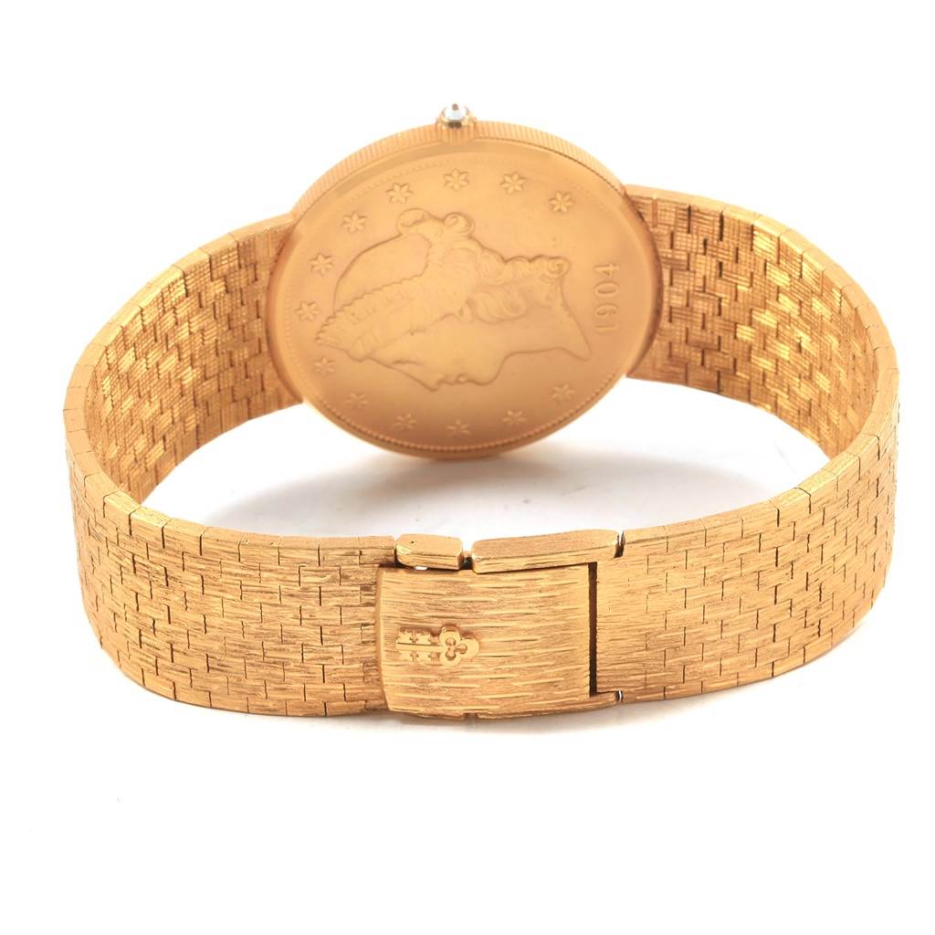 The image shows the back view of a Corum Coin Watch Men's Yellow Gold Black Dial Men's Yellow Gold Black Dial model, highlighting its gold coin back and woven bracelet.