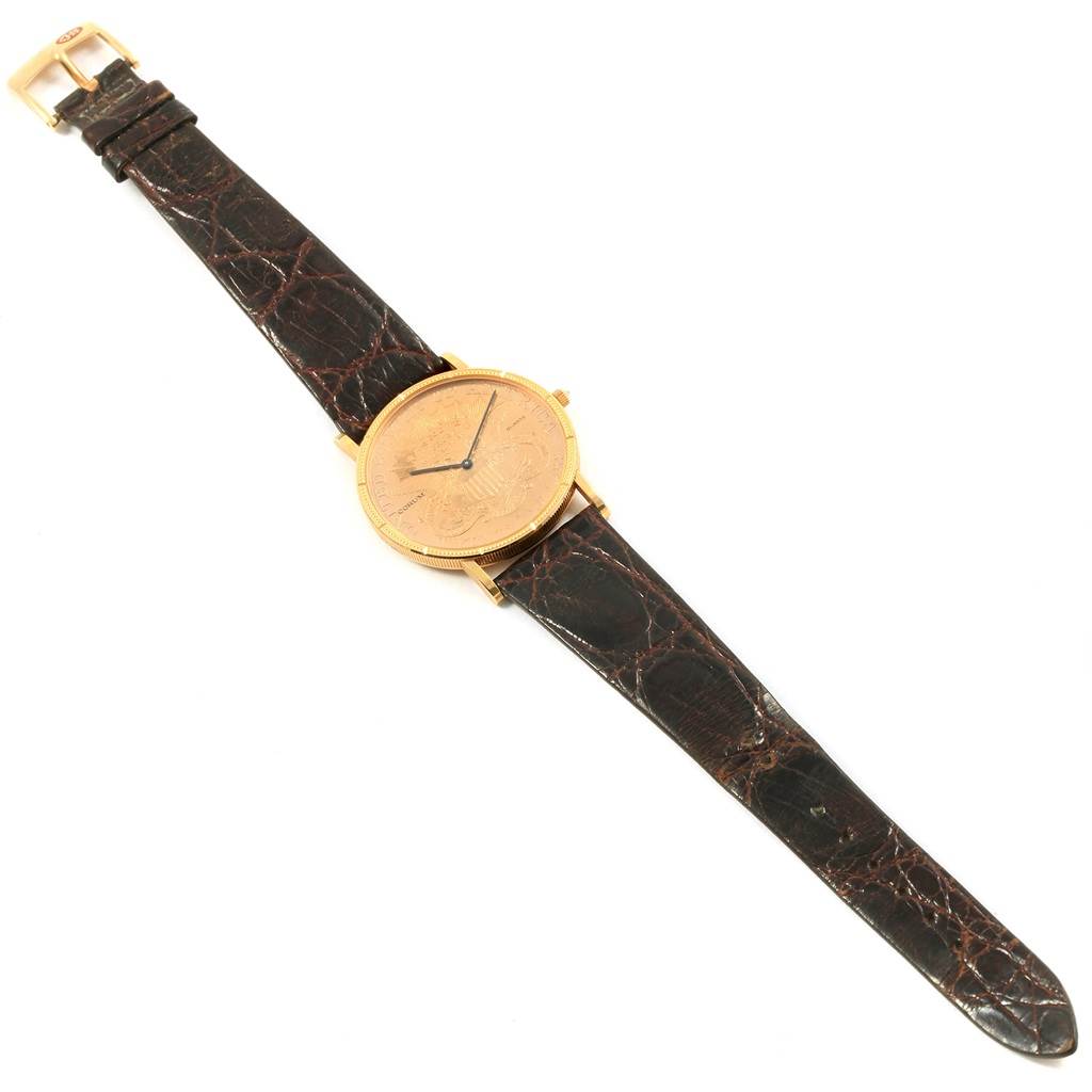The image shows a top-down view of a Corum Coin Watch  Men's Yellow Gold Black Dial  Men's Yellow Gold Black Dial, displaying its face, strap, and buckle.