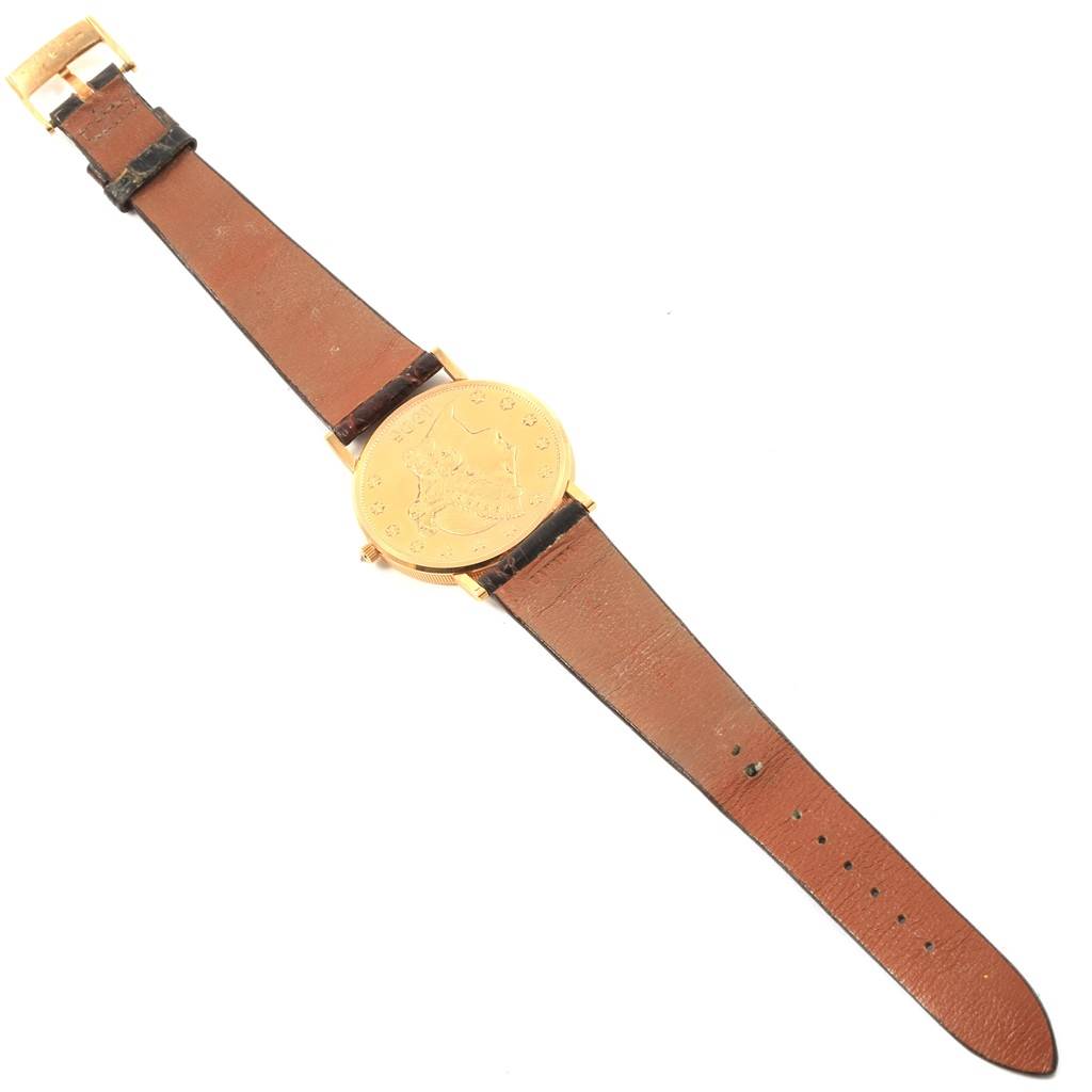 The image shows a top-down view of a Corum Coin Watch  Men's Yellow Gold Black Dial  Men's Yellow Gold Black Dial model, displaying its dial, case, strap, and buckle.