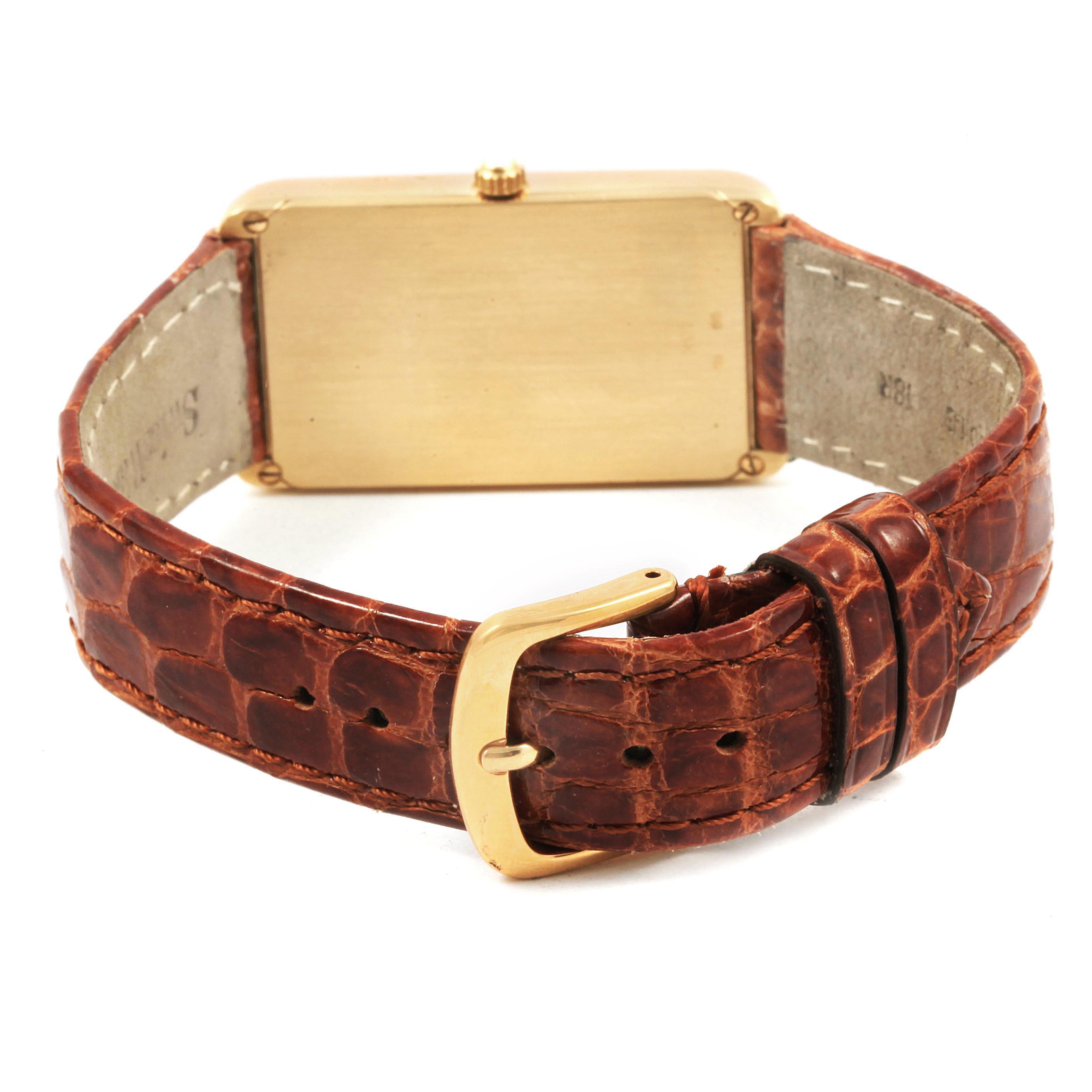 This image shows the back of the Corum 55400 Women's Yellow Gold Champagne Dial 55400 Women's Yellow Gold Champagne Dial 55400 5 Gram Ingot Yellow Gold Diamond Ladies Watch, focusing on the gold case and brown leather strap.