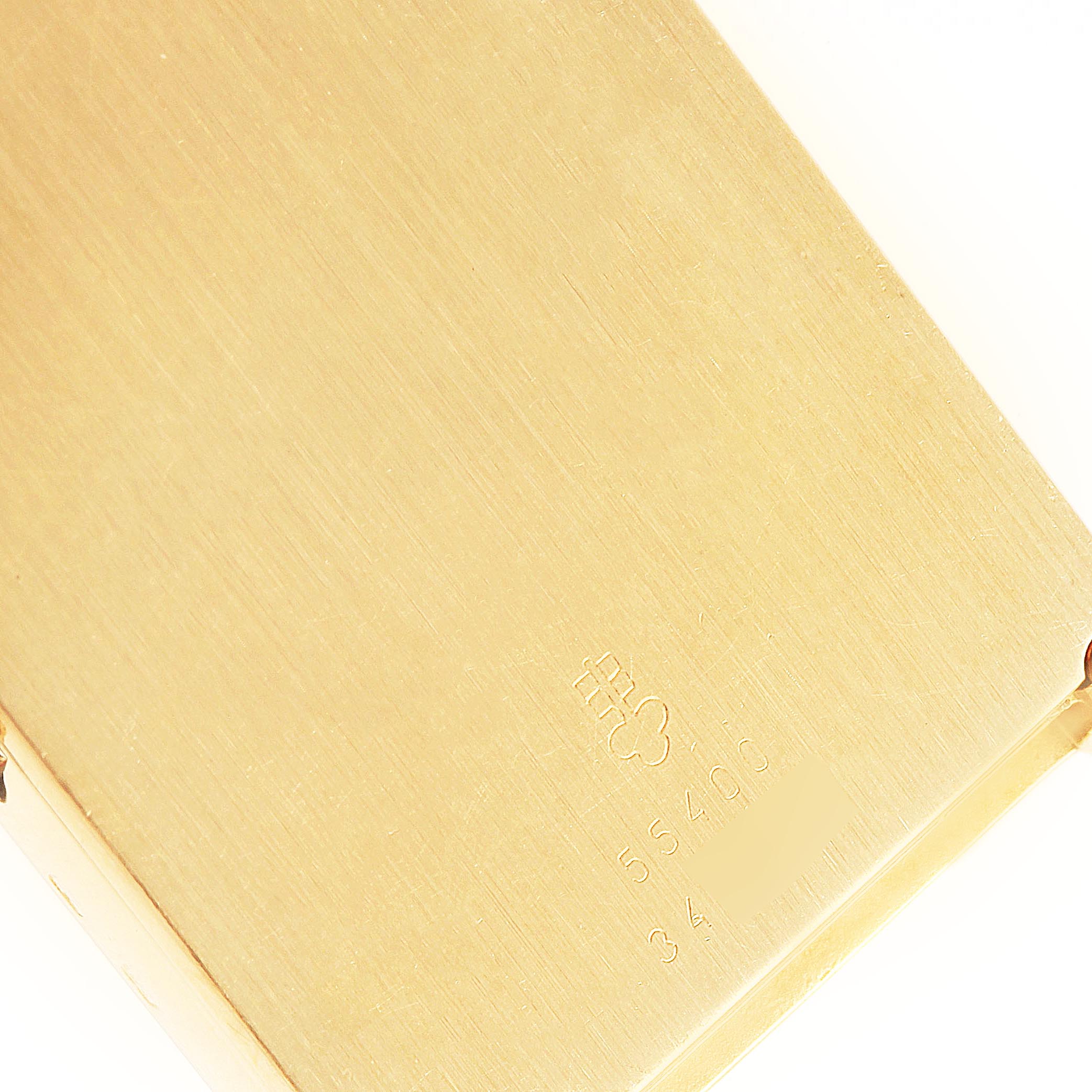 The image shows a close-up of the engraved back case of the Corum 55400 Women's Yellow Gold Champagne Dial 55400 Women's Yellow Gold Champagne Dial 5 Gram Ingot Yellow Gold Diamond Ladies Watch 55400 model.