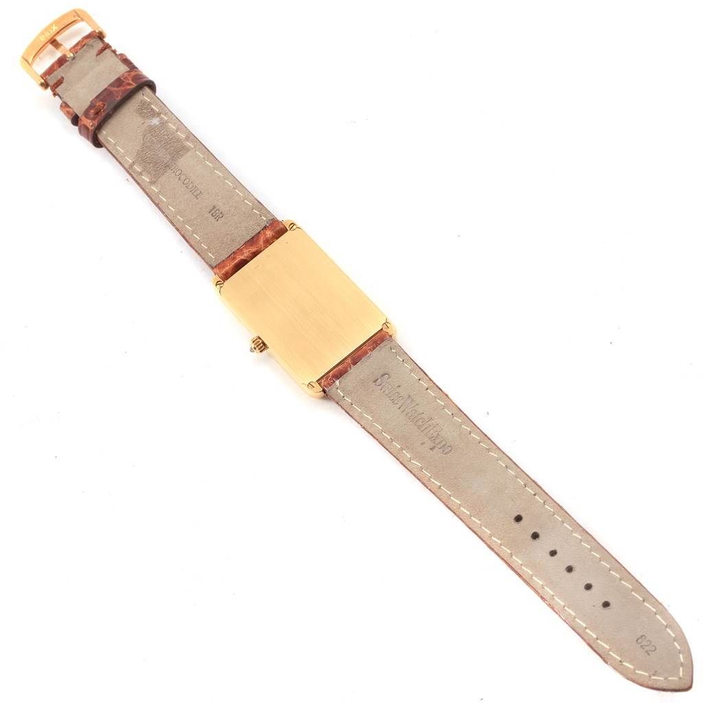 The image shows the back view of a Corum 55400 Women's Yellow Gold Champagne Dial 55400 Women's Yellow Gold Champagne Dial 5 Gram Ingot Yellow Gold Diamond Ladies Watch 55400 with its leather strap and gold buckle visible.