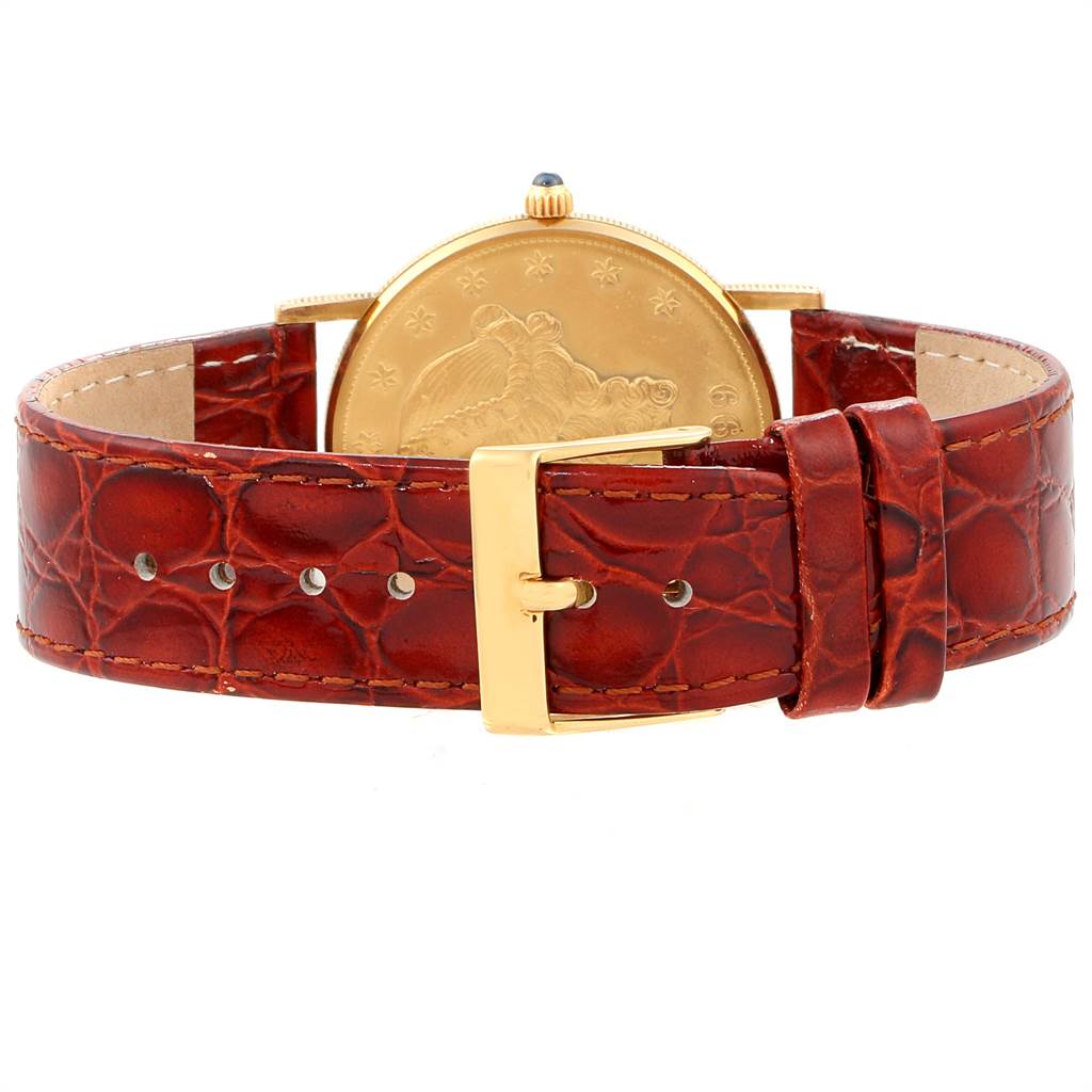 The image shows the back view of a Corum Coin Watch Men's Yellow Gold Black Dial Men's Yellow Gold Black Dial model, highlighting its leather strap and gold buckle.