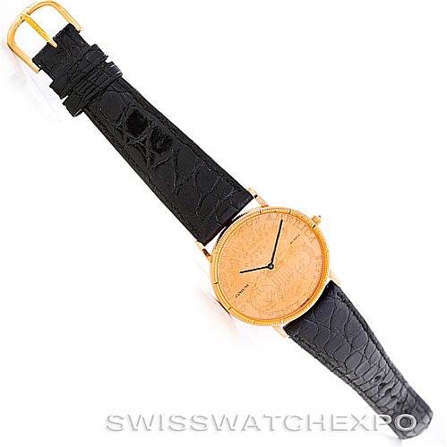 The image shows a top-view angle of a Corum Vintage watch with a gold-tone case and a black leather strap.