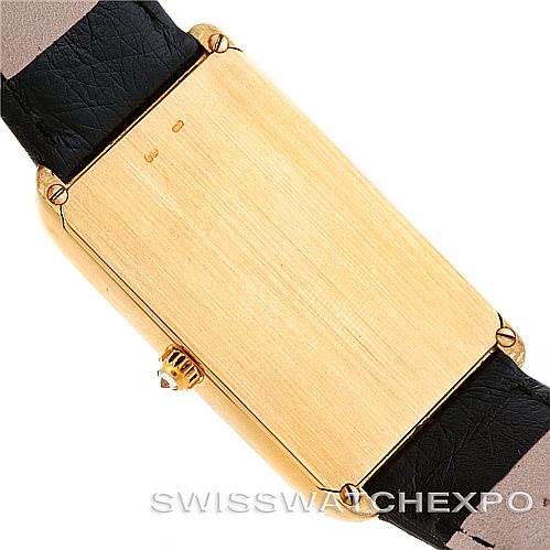 This image shows the back case of a Vintage Corum watch, highlighting the gold-tone case and black leather strap from a top-down angle.