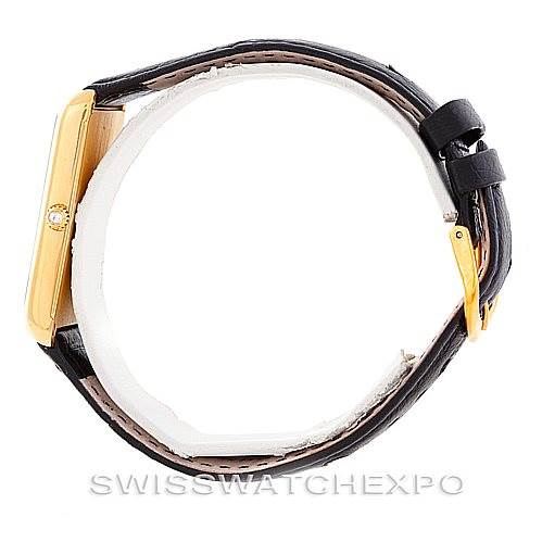 The image shows a side view of a Corum Vintage Men's Yellow Gold Champagne Dial Men's Yellow Gold Champagne Dial watch, highlighting its gold rectangular case and black leather strap.