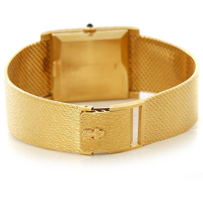 The image shows the back of a Corum Vintage 8764 Men's Yellow Gold Champagne Dial 8764 Men's Yellow Gold Champagne Dial model watch, focusing on its gold textured bracelet and closed clasp.