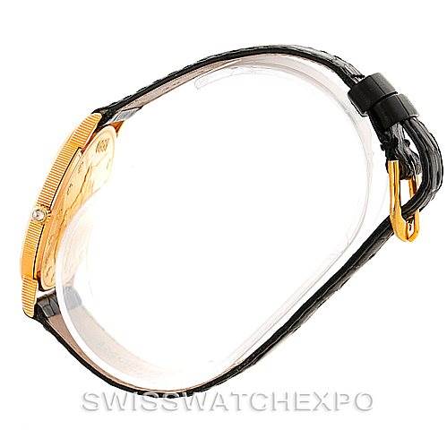 This image shows a side view of a Vintage Corum watch, highlighting its gold case, black leather strap, and buckle.