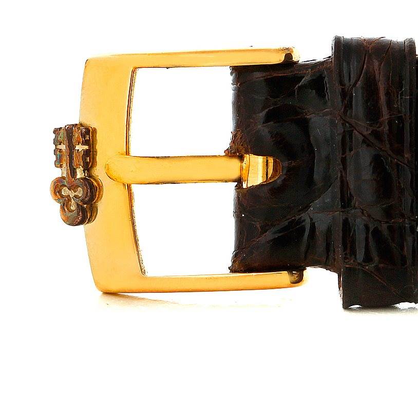 This image shows a close-up of the gold buckle and part of the leather strap from the Corum 42456 Women's Yellow Gold Champagne Dial 42456 Women's Yellow Gold Champagne Dial 18K Yellow Gold Diamond 5 Gram Ingot 999.9 Watch.