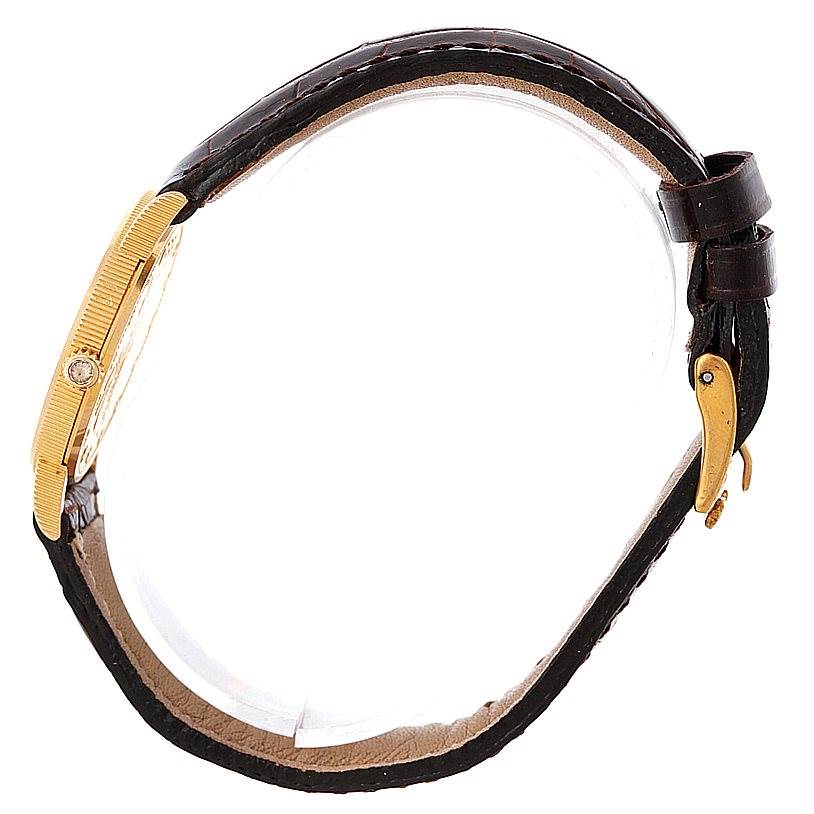 The image shows a side angle of the Corum Women's Yellow Gold Black Dial Women's Yellow Gold Black Dial Ladies 18K Yellow Gold 10 Dollars Coin Watch, featuring its band, bezel, and crown.