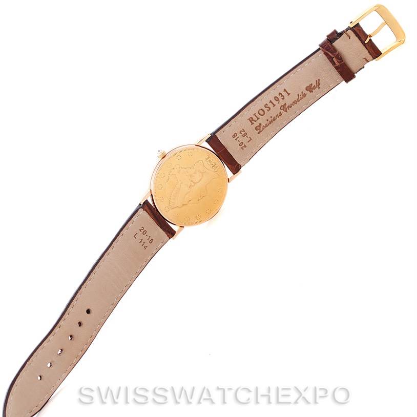 The image shows the back view of the Coin Watch model by Corum, displaying the watch face, strap with buckle, and inscriptions.