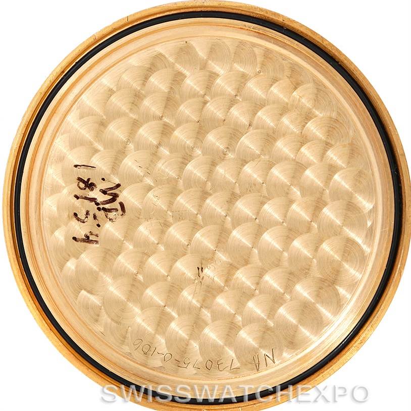 This image shows the inside case back of a Corum Coin Watch Men's Yellow Gold Black Dial Men's Yellow Gold Black Dial model, featuring a circular pattern and some engraved serial numbers.