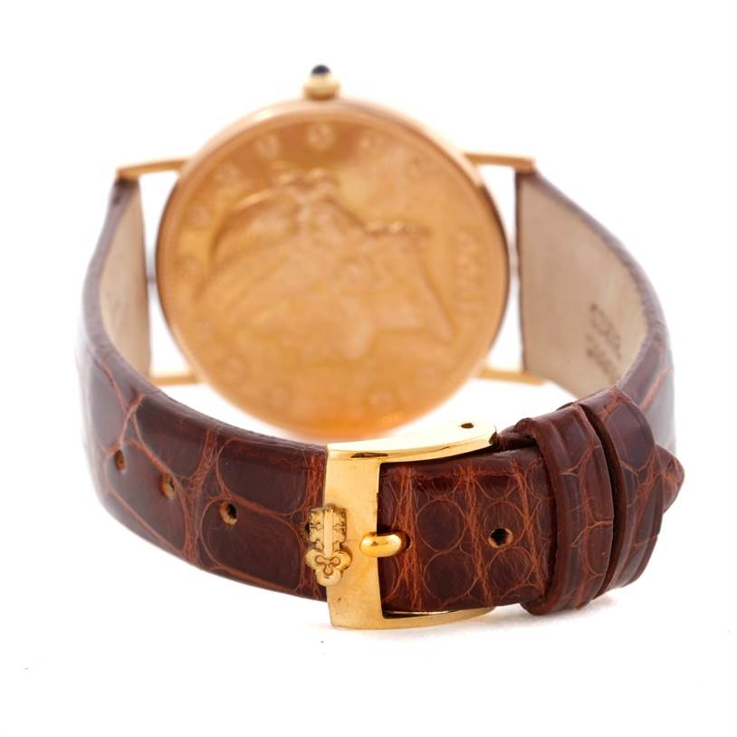 The image shows the back view of a Corum Coin Watch Men's Yellow Gold Black Dial Men's Yellow Gold Black Dial model, highlighting the brown leather strap and gold buckle.