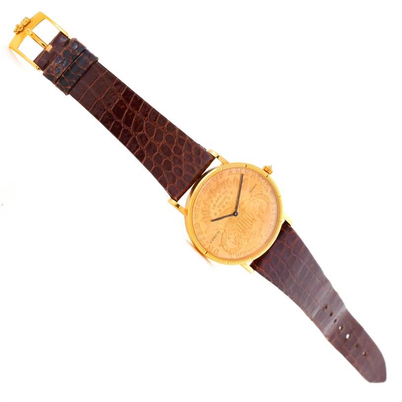 The image shows a Corum Coin Watch Men's Yellow Gold Black Dial Men's Yellow Gold Black Dial model from a top-down angle, displaying the full watch with a brown leather strap and gold coin-like dial.
