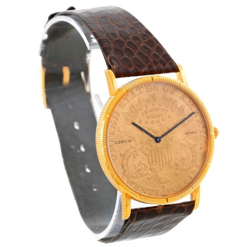 The image shows a Corum Coin Watch Men's Yellow Gold Black Dial Men's Yellow Gold Black Dial with a gold coin dial, black hands, and a textured brown leather strap, viewed from an angled front perspective.