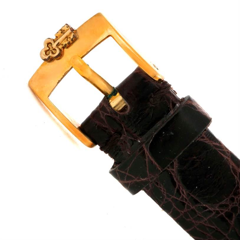 This close-up image shows the gold buckle and leather strap of the Corum Women's Yellow Gold Black Dial Women's Yellow Gold Black Dial 22K Yellow Gold 10 Dollars Coin Diamond Ladies Watch.