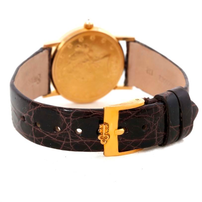 The image shows a rear view of the Corum Women's Yellow Gold Black Dial Women's Yellow Gold Black Dial 22K Yellow Gold 10 Dollars Coin Diamond Ladies Watch, highlighting its leather strap and gold clasp.