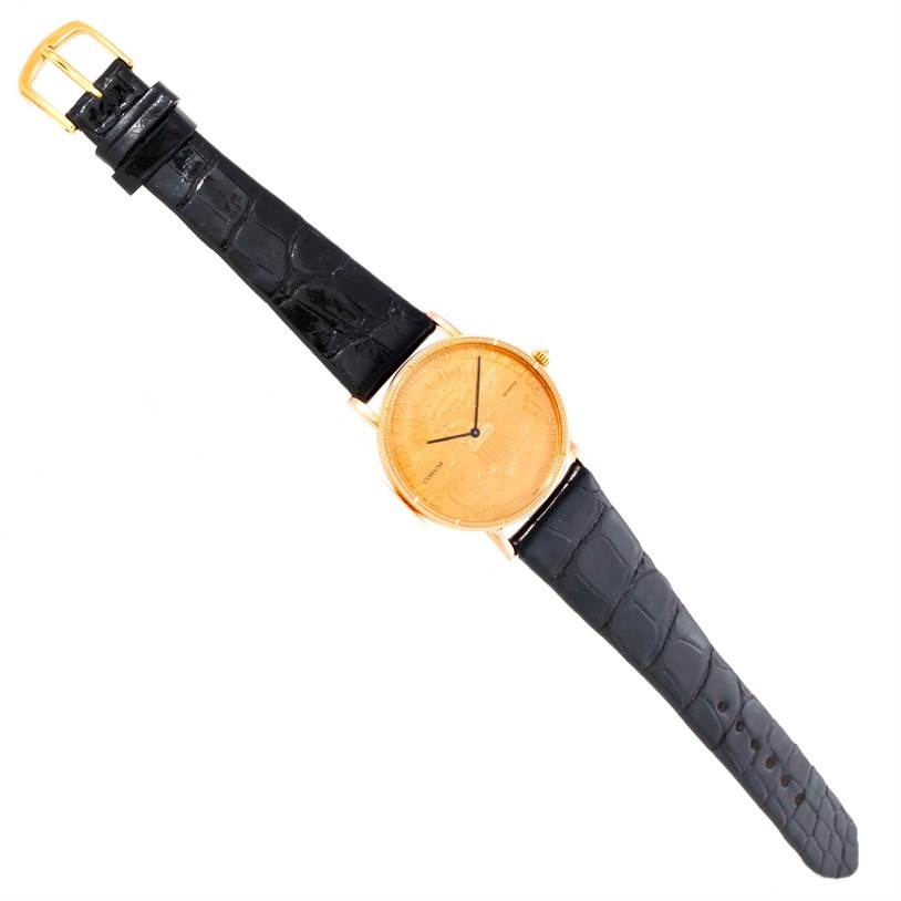 The Corum Coin Watch Men's Yellow Gold Black Dial Men's Yellow Gold Black Dial model is shown from a top-down angle, highlighting its gold dial, black leather strap, and gold buckle.