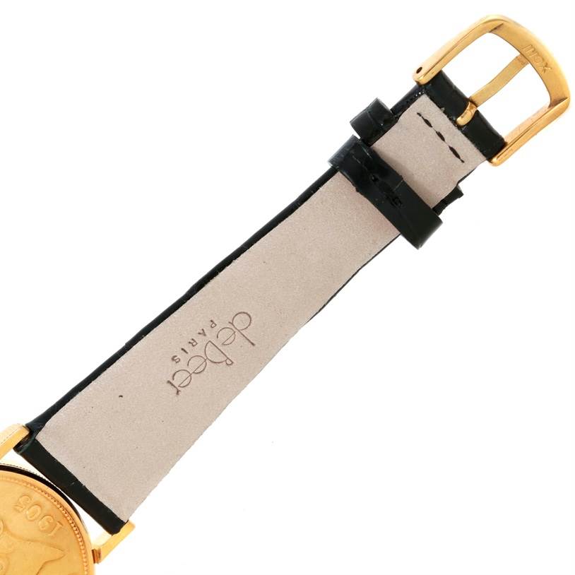 The image shows the buckle and part of the leather strap, along with a portion of the face of the Coin Watch model by Corum.