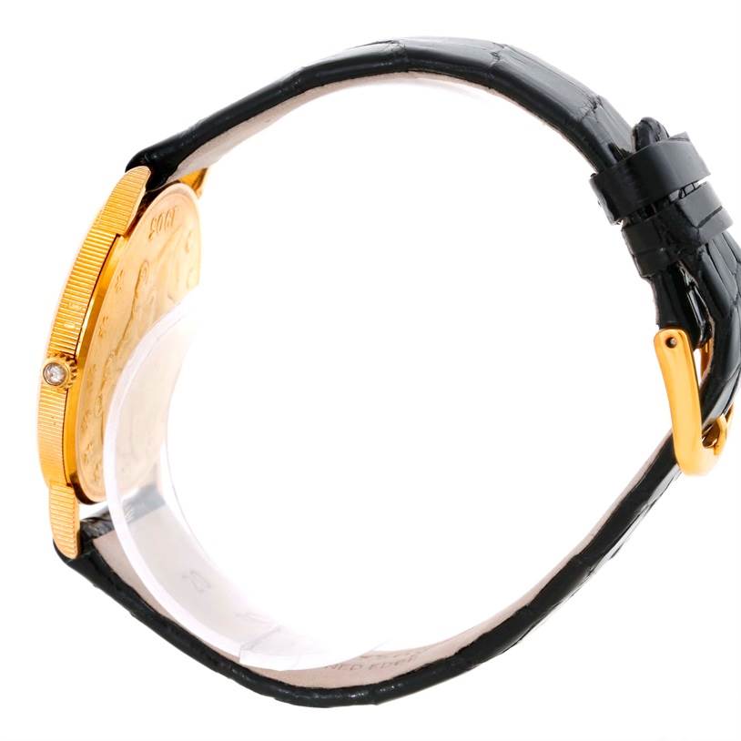 The image shows the side view of a Corum Coin Watch Men's Yellow Gold Black Dial Men's Yellow Gold Black Dial model, highlighting its golden case and black leather strap.