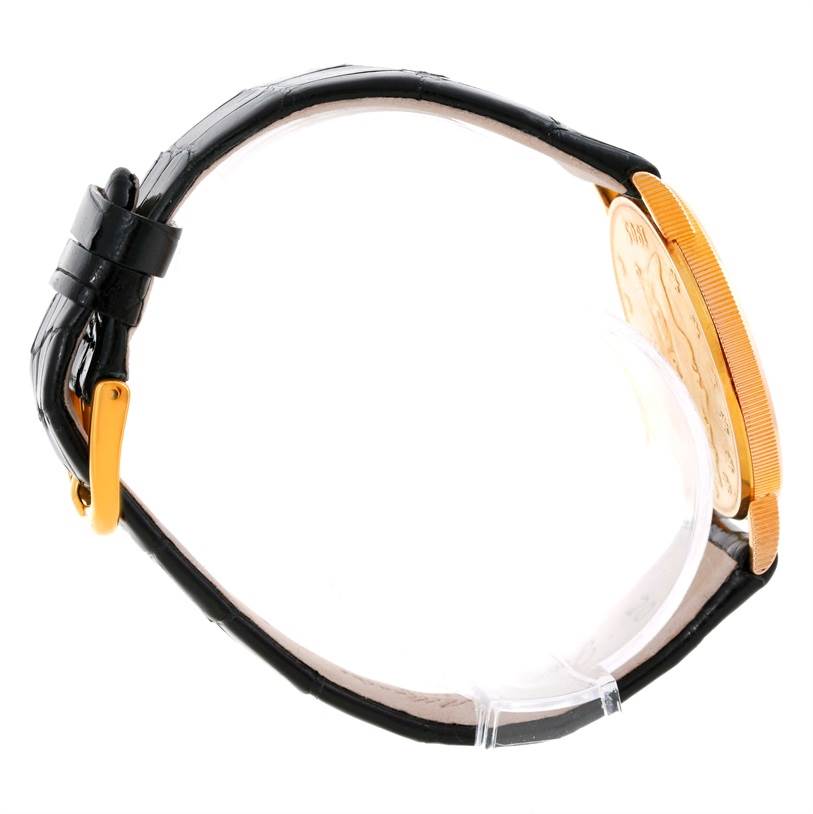 The image shows a side view of the Corum Coin Watch Men's Yellow Gold Black Dial Men's Yellow Gold Black Dial model, highlighting its black strap and gold case edge.