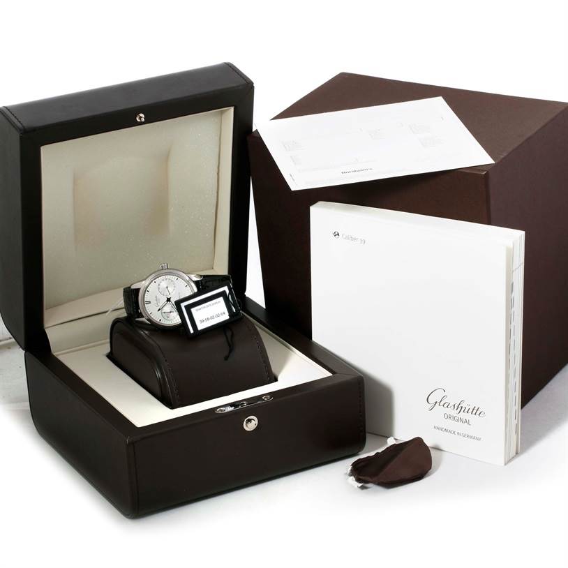 The image shows a Glashütte Senator watch in its box, accompanied by documentation and accessories, viewed at an angle from the front.