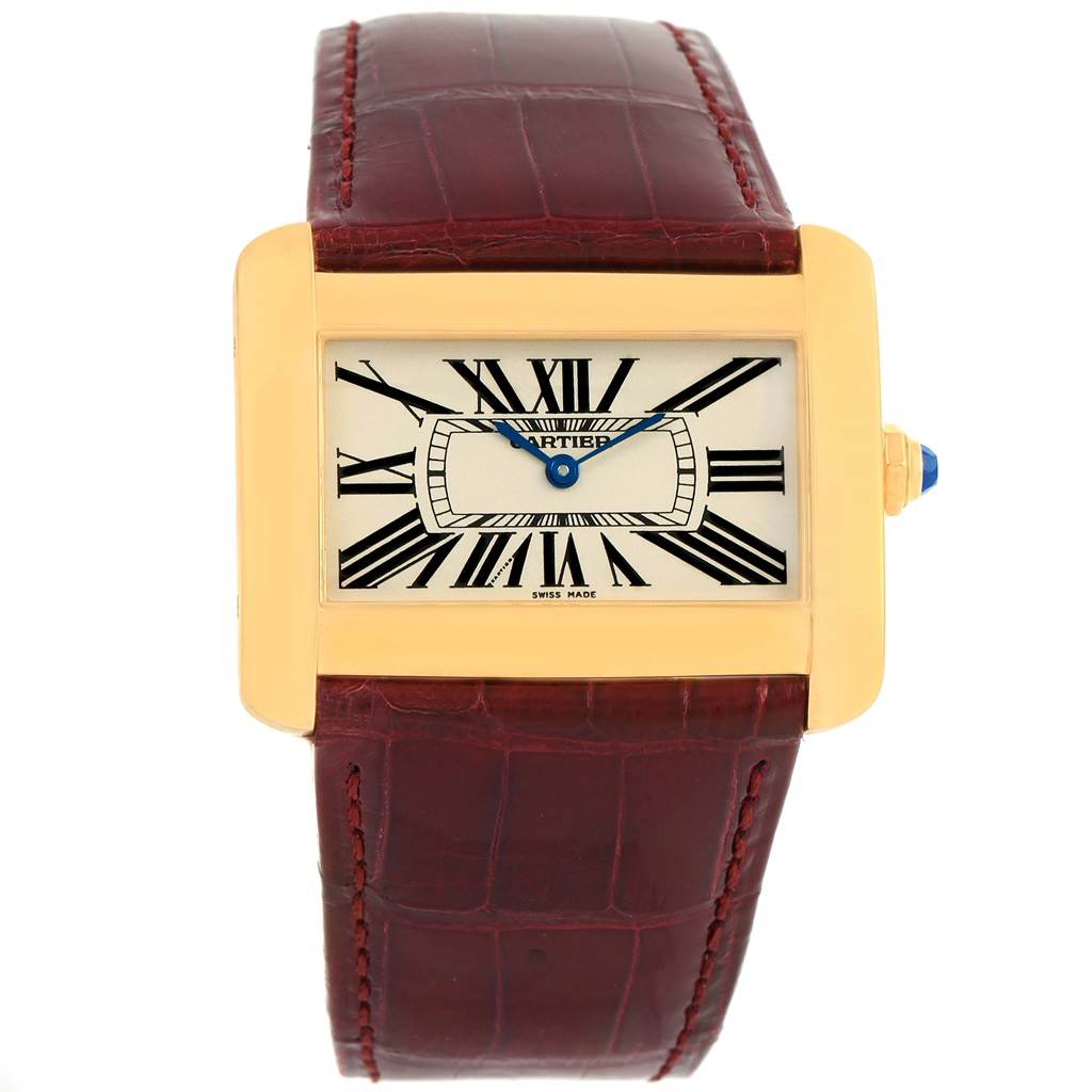 The image shows a front view of the Cartier Tank Divan W6300556? Yellow Gold Silver Dial W6300556? Yellow Gold Silver Dial watch, featuring a rectangular gold case, Roman numerals, and a brown leather strap.