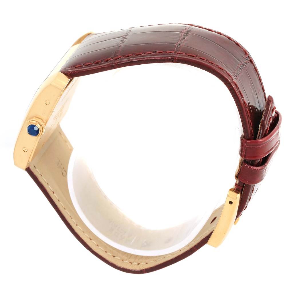 The image shows a side view of the Cartier Tank Divan W6300556? Yellow Gold Silver Dial W6300556? Yellow Gold Silver Dial watch, highlighting the gold case, crown with a blue gemstone, and brown leather strap.