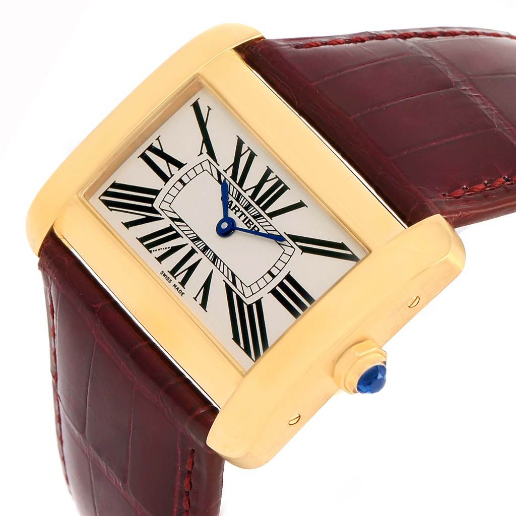 The image shows a Cartier Tank Divan W6300556? Yellow Gold Silver Dial W6300556? Yellow Gold Silver Dial watch at an angle highlighting its square face, Roman numerals, blue hands, brown leather strap, and gold casing.