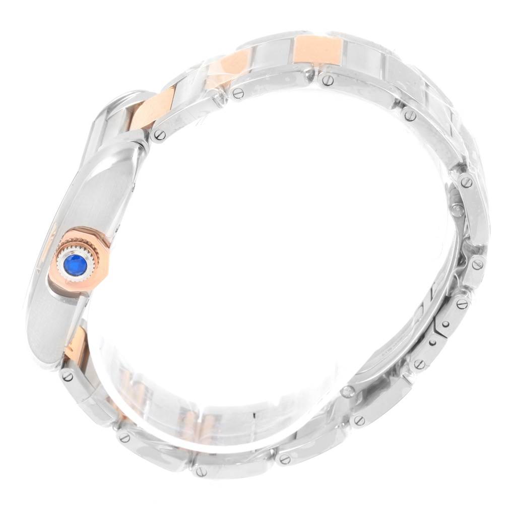 This image shows a close-up side view of the Cartier Tank Anglaise WT100034 Steel and Gold (two tone) Silver Dial WT100034 Steel and Gold (two tone) Silver Dial watch, highlighting its bracelet and blue gemstone crown.