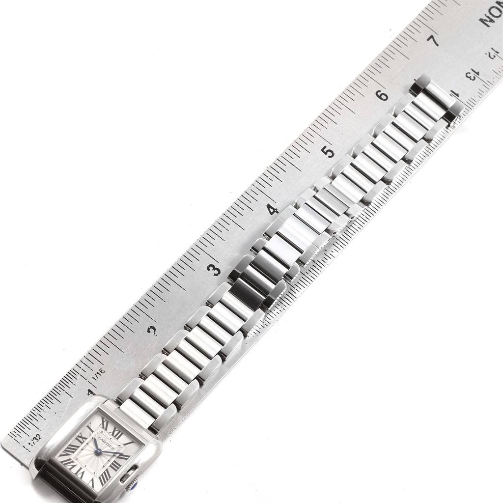 This image shows a top-down view of a Cartier Tank Anglaise W5310022 Women's Stainless Steel Silver Dial W5310022 Women's Stainless Steel Silver Dial watch, including the face and bracelet next to a ruler for measurement.