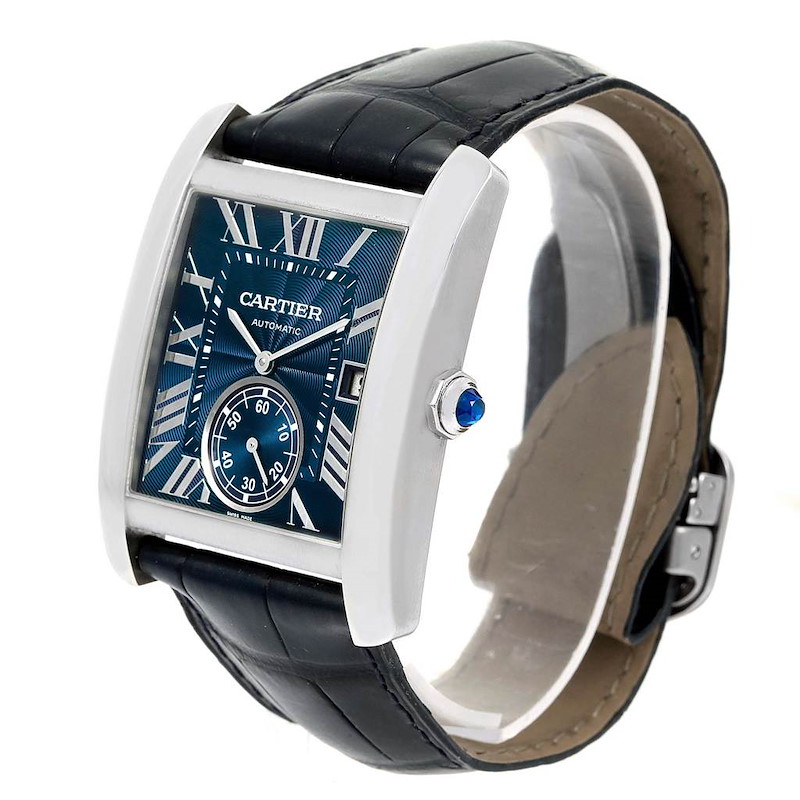 The Cartier Tank MC watch is shown at a three-quarter angle, displaying its rectangular face, blue dial, leather strap, and crown detail.