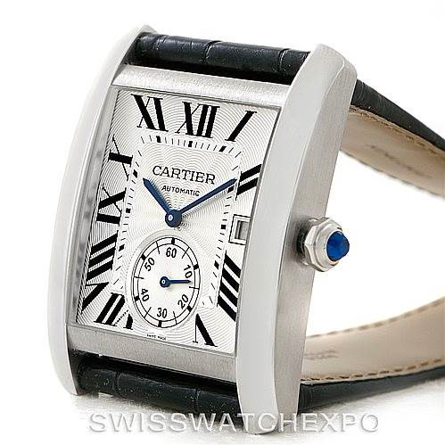 This image shows a Cartier Tank MC watch at a slight angle, highlighting its face, blue hands, and crown with a blue sapphire cabochon.