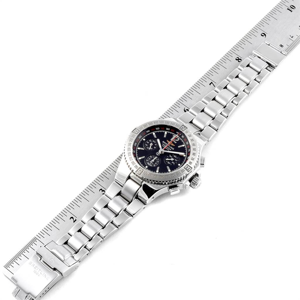 The image shows a top view of the Breitling Chronomatic A39362 Men's Stainless Steel Black Dial A39362 Men's Stainless Steel Black Dial watch with its silver bracelet laid out alongside a ruler.