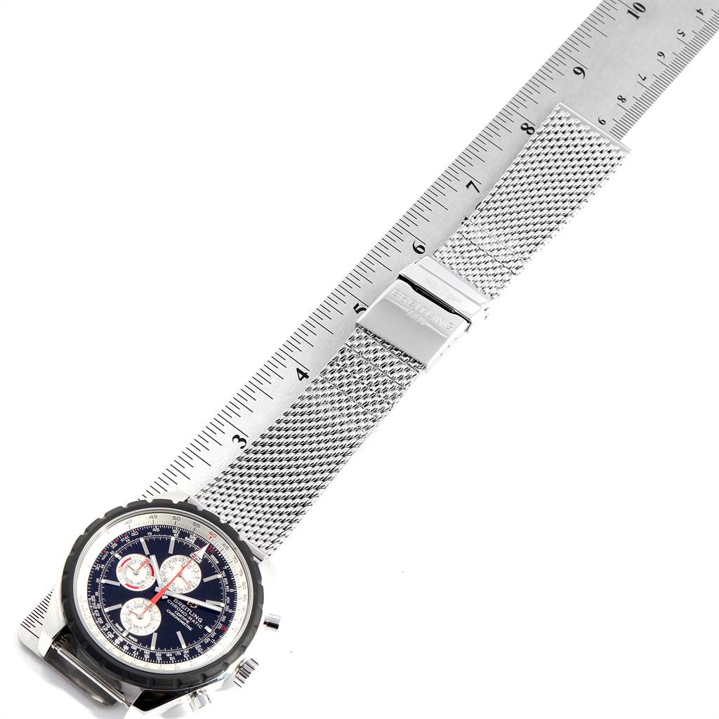 The image shows the face and metal mesh band of a Breitling Chronomatic A19360 Men's Stainless Steel Black Dial A19360 Men's Stainless Steel Black Dial watch positioned next to a ruler.