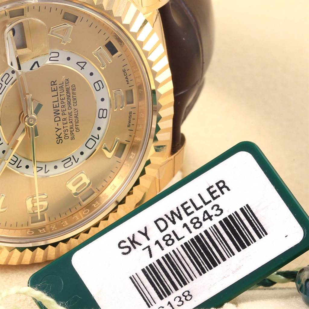 This image shows a close-up of the face and bezel of a Rolex Sky-Dweller 326138 Men's Yellow Gold Champagne Dial 326138 Men's Yellow Gold Champagne Dial watch along with its tag.